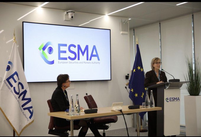 A press conference or meeting room at ESMA (European Securities and Markets Authority), showing a woman speaking at a podium with ESMA flags and logos visible in the background.