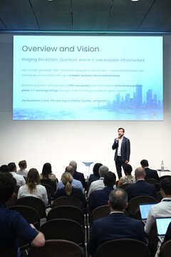 A presenter stands on stage at the World Tech Conference Milan, addressing an audience while a large screen displays a slide titled "Overview and Vision" outlining strategies for bridging structural and infrastructure gaps in preparation for a post-quantum world — directly illustrating the post's reference to Davide Costa sharing DAC's forward-looking vision.