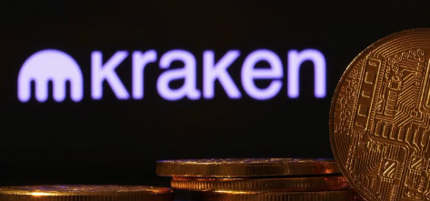 A photograph of stacked gold Bitcoin coins with the illuminated Kraken cryptocurrency exchange logo displayed in the background.
