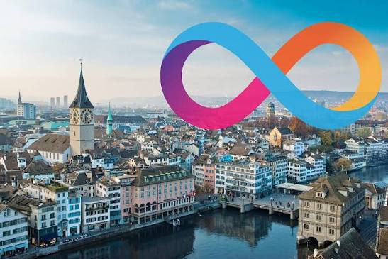An aerial view of a European city with a river and historic buildings is overlaid with a colorful Meta (Facebook) infinity logo.