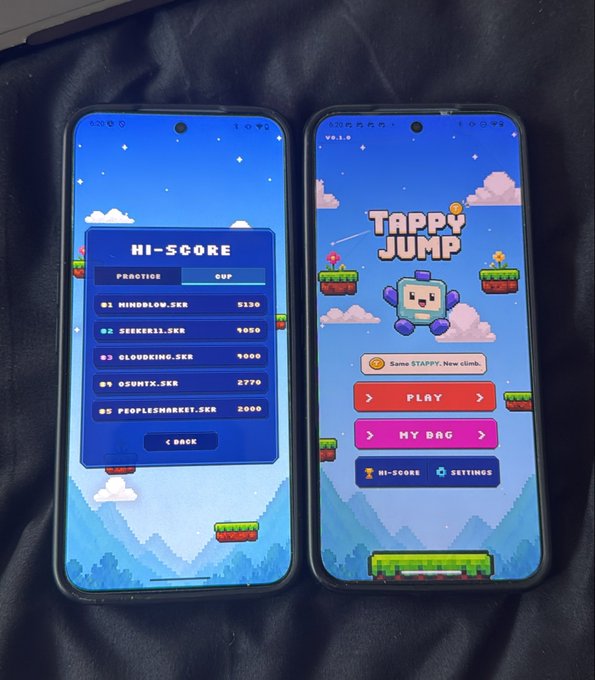 The image shows two cell phones placed side by side with a screen displaying "Tappy Jump" game information. The phones are positioned such that one phone is at the top of the frame, while the other is at the bottom. Both phones have screens showing the game's interface and scoreboards for the game. The text on the image includes details about the game release date, the number of players, and a description of the game's scoreboard.