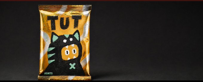 A snack package labeled 'TUT AGNTS' featuring a black character mascot with an orange face on an orange background.