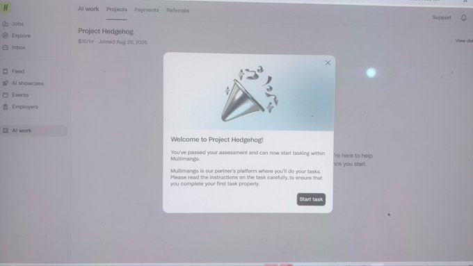 A screenshot of a computer monitor showing a 'Project Hedgehog' task on a platform, with a pop-up displaying a party popper icon and a welcome message.