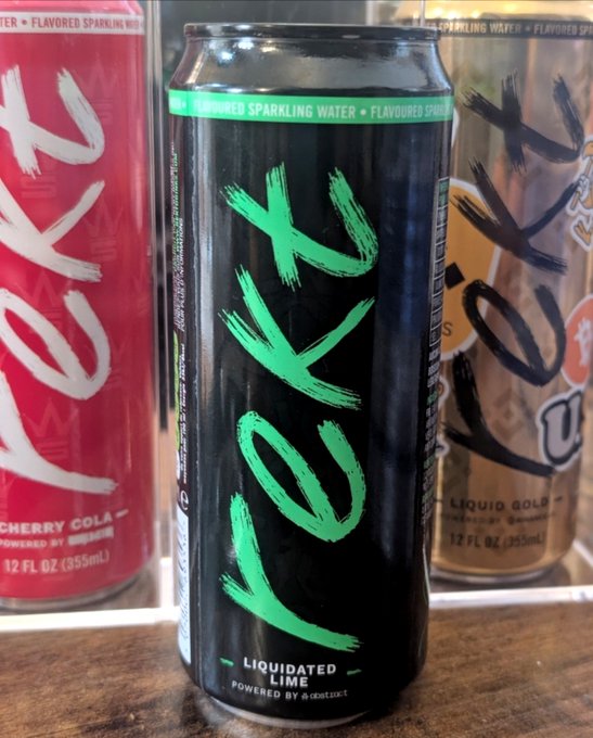 A close-up of three 'JOYK' brand sparkling water cans, with the central black can labeled 'LIQUIDATED LIME' in green brushstroke text, flanked by a red 'CHERRY COLA' can and a gold 'LIQUID GOLD' can.