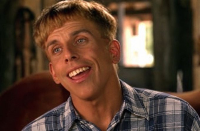 A blond man in a blue plaid shirt smiles with an amused, knowing expression. The image humorously conveys the poster's confident claim that $LINK will never trade below $9 again, suggesting the optimistic prediction is as assured as his cheerful certainty.