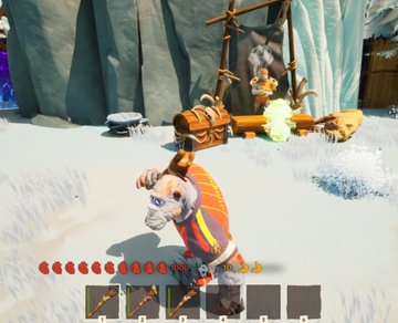 A screenshot from a video game shows a character in colorful clothing standing in a snowy environment with a treasure chest and wooden structures nearby, displaying a health bar and inventory slots at the bottom of the screen.