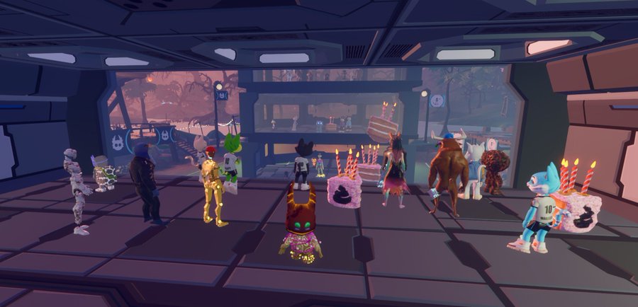 A 3D rendering of various NFT character avatars gathered in a futuristic sci-fi room holding birthday cakes, suggesting a virtual celebration or party event.