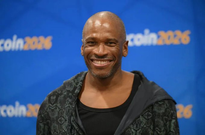 Arthur Hayes smiles at the Bitcoin 2026 conference, with "Bitcoin 2026" branding visible in the background, as he shares his hot take that the CLARITY Act could hinder rather than help Bitcoin and U.S. crypto innovation by acting as a gatekeeper.