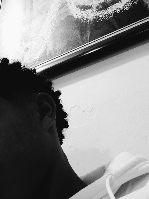 A black-and-white photo shows the back of a person's head with curly hair as they lean toward a foggy window, with their silhouette and ear visible against the bright glass. The intimate, contemplative pose pairs with the casual "gm fren" greeting, suggesting a quiet morning moment shared with the thread.