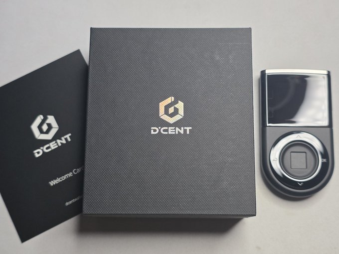 The image features a black wallet with gold lettering that reads "DCENTWALLETS". It appears to be a product of Ledger, as indicated by the accompanying text. The wallet is placed next to an instruction manual or guide for the product, suggesting that it might have some unique features or functionalities not immediately apparent from its appearance alone.

The post also mentions that this particular wallet has been gaining popularity under the Ledger community and is being recommended by them. This implies that there could be a specific feature or characteristic of the wallet that has caught their attention, making it stand out among other wallets in the market.