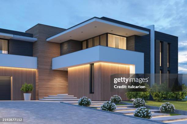 A modern, multi-story home showcases sleek architecture with warm interior lighting glowing through large windows at dusk, while the Getty Images watermark "tulcarion" and ID "2192877112" appear on the image — notably, this highly realistic AI-generated rendering of a luxurious house shares no visual connection to the post about the web3 game Sleepagotchi.