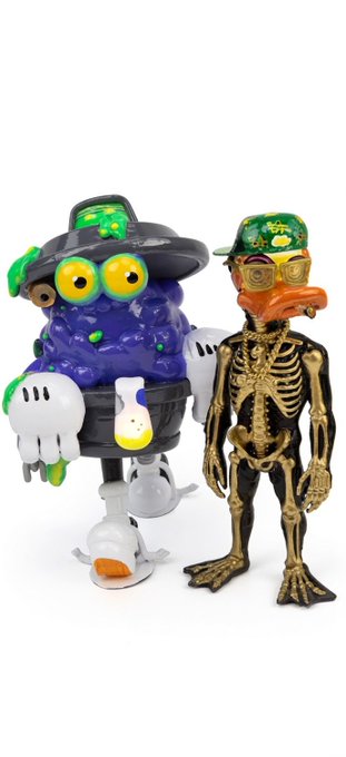 Two designer art toys: a purple bubble-like creature in a black witch hat with a skull on its body, and a black skeleton duck with a green camo cap and orange bill.