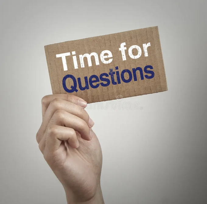 The image shows a person's hand holding up a brown cardboard sign with white text that says "Time for Questions". The background of the image is a plain gray color, which contrasts with the vibrant blue and white colors of the sign. The focus on this particular image suggests it might be related to a discussion or debate about market rules or market resolution in the context of polyamory.