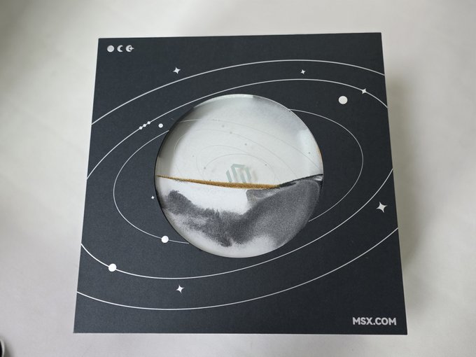 A circular window in a black MSX-branded card displays silver and grey marbled mooncakes, revealing the festive gift given for the Mid-Autumn Festival celebration. The card's celestial design with orbital rings complements the celebratory post wishing prosperity on US stocks.