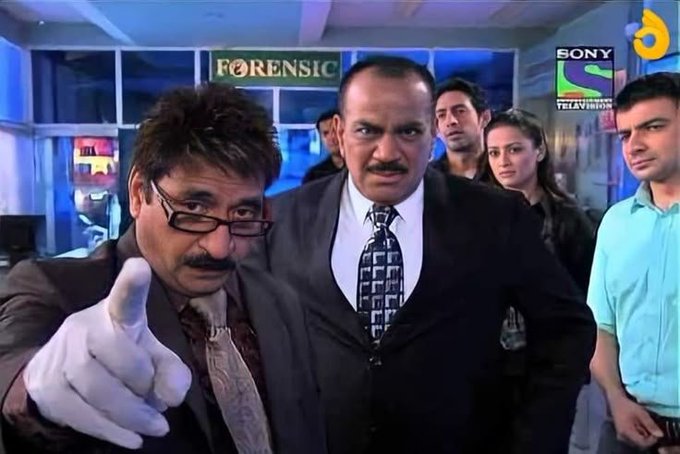 A scene from the Sony SAB television show 'Forensic', showing a man in glasses pointing while surrounded by other characters in a lab setting.