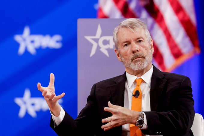 Michael Saylor, Executive Chairman of MicroStrategy, speaks at a CPAC event, gesturing with his hands. The image connects to the post's satirical take on Saylor's Bitcoin investment strategy, highlighting the irony of his long-term "never sell" advice despite recently offloading 32 BTC.