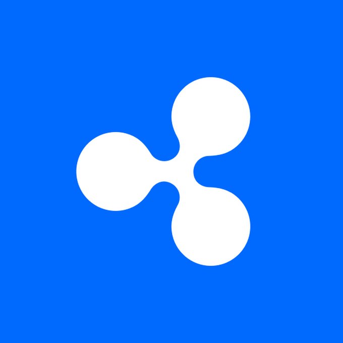 The image features a white Ripple (XRP) logo—a stylized three-circle design—centered on a solid blue background, symbolizing the cryptocurrency mentioned in the accompanying post about XRP pulling back to around $1.40 due to stronger US jobs data and rising Fed rate hike expectations.