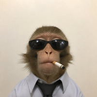 A humorous image of a monkey wearing black sunglasses and a white shirt with a black tie, holding a cigar in its mouth.