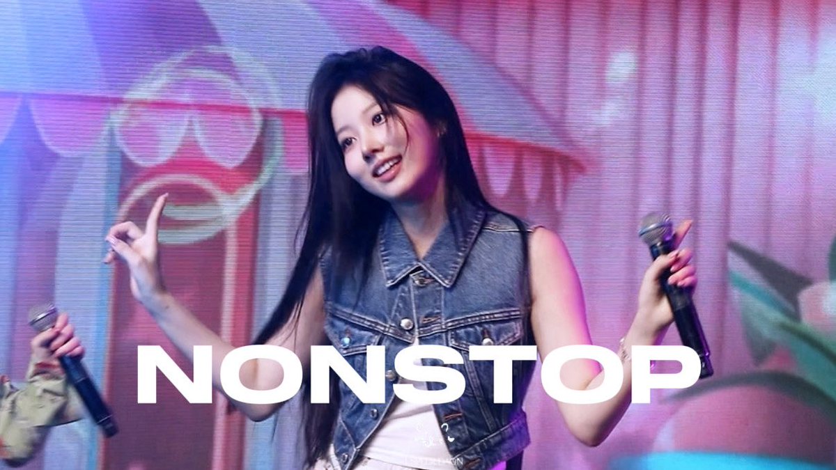 A young woman with long dark hair wearing a denim vest performs on stage holding a microphone, with the word "NONSTOP" overlaid in large white text.
