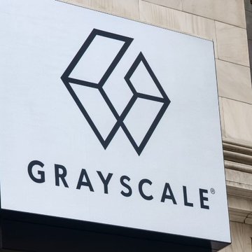 A white sign featuring the Grayscale Investments logo, which is a stylized 'G' formed by geometric shapes, with the word 'GRAYSCALE' printed below it.