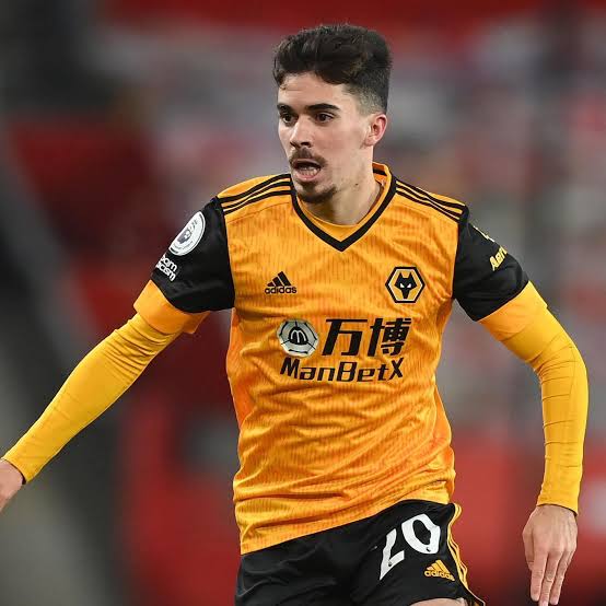 A Wolverhampton Wanderers footballer in an orange-and-black No. 29 kit runs during a match, with “ManBetX,” the Premier League sleeve patch, and club crest visible. Used as a humorous “POV: Bitcoin in 2010” meme, it evokes Bitcoin’s early, volatile years before its later rise.