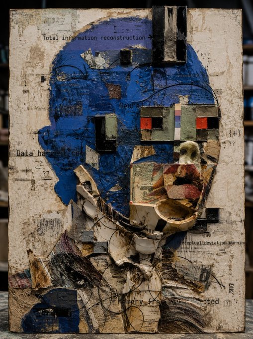 A mixed-media artwork on canvas portrays an abstract human face composed of blue paint, textured materials, and collage elements, with partially visible text like 'Total information reconstruction' and 'Memory fragmented'.