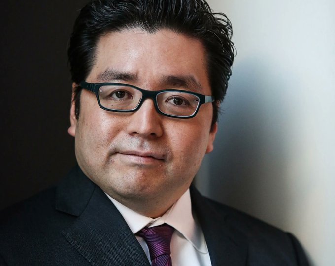 The image shows a professional headshot of an Asian man wearing glasses and a dark suit with a maroon tie, presumably Tom Lee, whose Bitmine holding of 5.7 million $ETH valued at $8.9 billion is highlighted as a major Ethereum treasury position projected to generate $211 million in annual staking revenue.