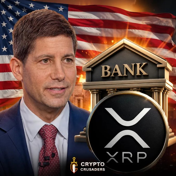 A man in a suit stands next to a bank illustration and an XRP cryptocurrency logo, with an American flag and flames in the background; the image is branded "CRYPTO CRUSADERS" at the bottom.