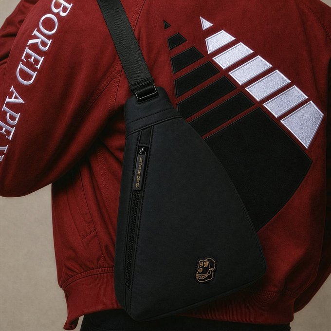 A person wears a maroon "BORED APE" jacket while carrying a black triangular satchel featuring the "CALL OF DUTY COLLECT." logo and a small ape emblem, humorously illustrating the Bored Ape Yacht Club culture referenced in the playful ApeFest seating joke.