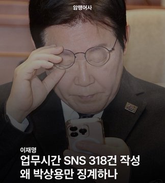 The image shows Prosecutor Lee Jae-myung adjusting his round glasses while looking at an iPhone, with Korean text "입병이사" (impostor) at the top and "이재명 업무시간 SNS 318건 작성 왜 박상용만 정죄하나" (Why only Park Sang-yong is punished when Lee Jae-myung wrote 318 SNS posts during work hours) at the bottom. The caption and image together appear to criticize Lee Jae-myung for allegedly wasting work time on social media while contrasting it with the legal consequences faced by Park Sang-yong.