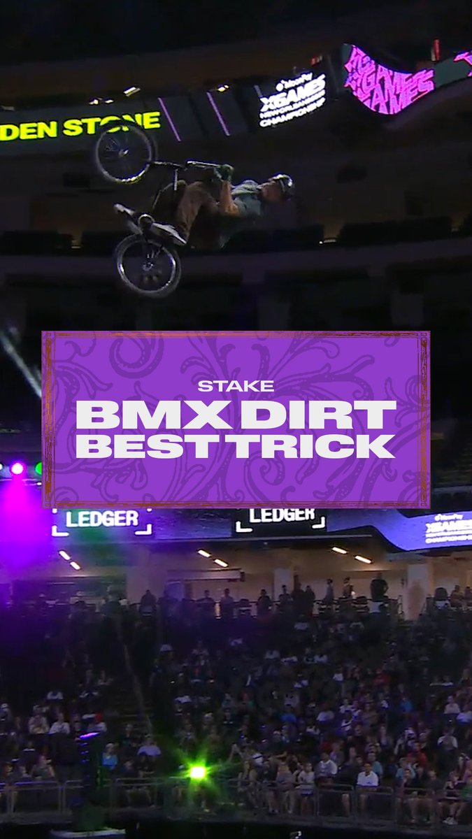 A BMX rider performs an inverted aerial trick mid-air at the X Games League Championship in New Orleans, with a purple graphic overlay announcing "STAKE BMX DIRT BEST TRICK" and visible "X GAMES" and "LEDGER" signage above a large arena crowd. The image captures the high-flying action that earned Kaden Stone his bronze medal in the event.