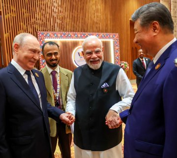 Leaders Vladimir Putin, Narendra Modi, and Xi Jinping are captured shaking hands during a formal diplomatic meeting.