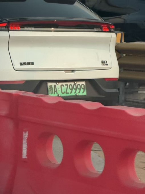 The rear of a white NIO Sky Edition car with a green Chinese license plate reading '浙A·CZ9999' is parked behind a red plastic barrier.