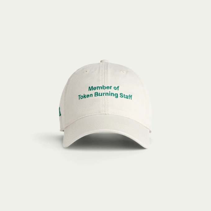 A beige baseball cap features embroidered green text reading 'Member of Token Burning Staff'.