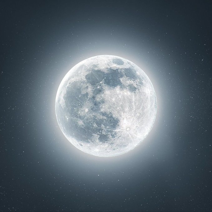 A bright full moon glowing against a dark, starry night sky.