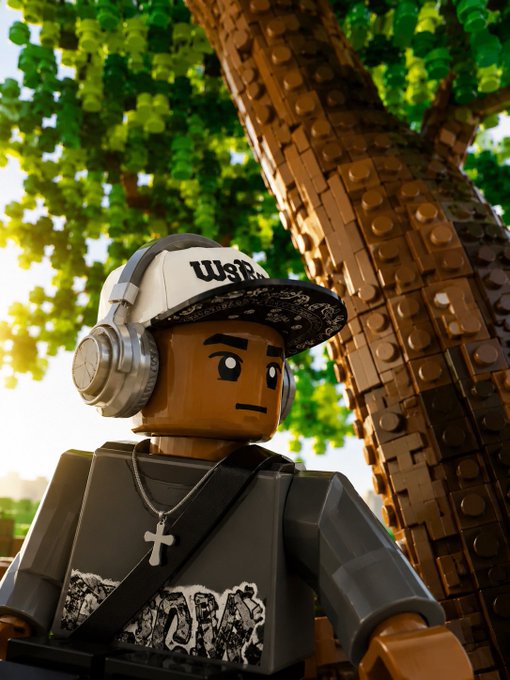 A LEGO-style figure with a brown face, wearing a white cap, headphones, a gray shirt with a cross necklace, stands near a brick-textured tree trunk.