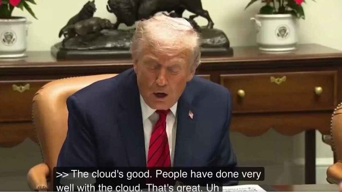 The image shows a man sitting at a desk, wearing a suit and tie, with his head down looking at papers or documents. The text in the image reads "THE CLOUD'S GOOD. PEOPLE HAVE DONE VERY WELL WITH THE CLOUD. THAT'S GREAT. UNH". This statement is related to the post about Donald Trump talking about IBM stock, as it seems that he might be discussing a business deal or an investment opportunity involving IBM. The image also includes a reference to the Hedera Council member and another reference to the last time Trump publicly praised a council member, which suggests that this discussion could be taking place in a political context related to the Hedera Council.