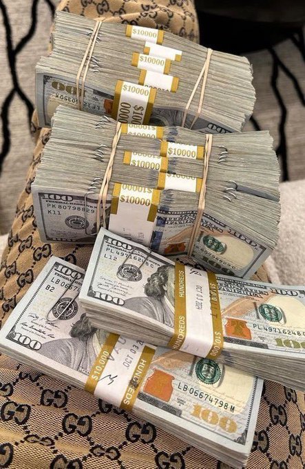 Several stacks of $100 bills bundled with $10,000 currency straps, arranged on a Gucci-patterned surface.