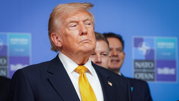 Donald Trump stands with a serious expression at what appears to be a NATO event, as the accompanying post claims he now owns a bank through his family's crypto company.
