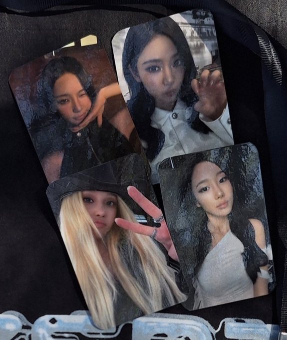 Four photocards featuring members of the K-pop group BLACKPINK (Jisoo, Jennie, Rosé, and Jennie again) are arranged inside what appears to be a bag or pouch.