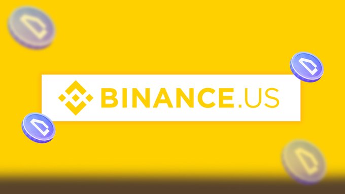 The image displays a promotional banner featuring the "BINANCE.US" logo in a white rectangle against a bright yellow background, surrounded by floating blue and yellow coin tokens. It visually supports the announcement of a new user welcome offer for $WOD on the Binance.US platform, highlighting the exchange's branding while promoting the sponsored deposit bonus.