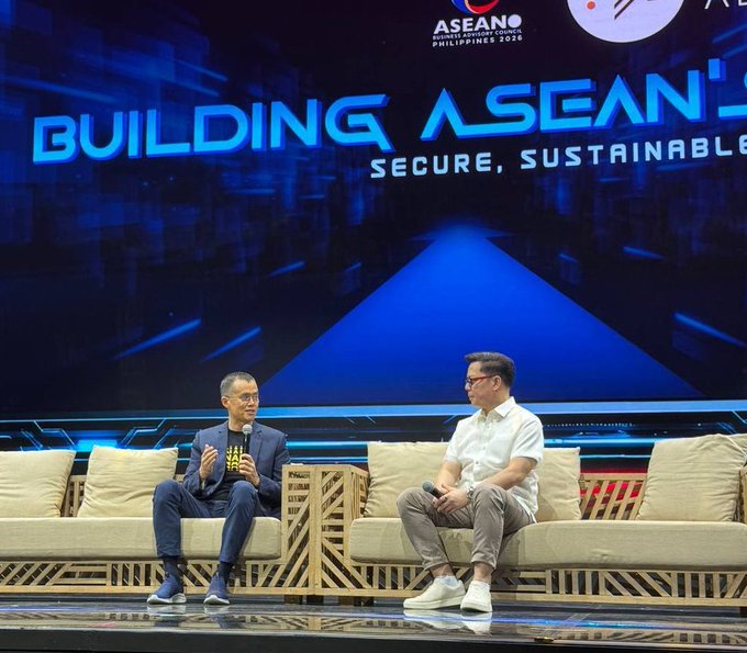 Two men sit on beige couches on a stage at an ASEAN event with the backdrop reading 'BUILDING ASEAN'S SECURE, SUSTAINABLE' and 'ASEAN PHILIPPINES 2026' at the top.
