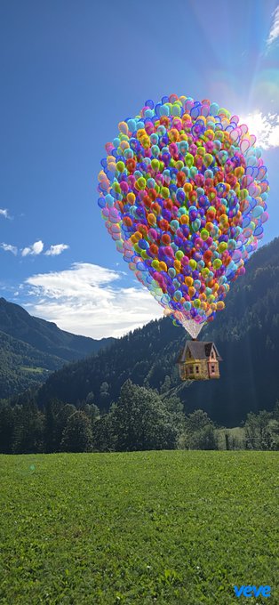 A digital illustration of a house lifted by a massive cluster of colorful balloons, floating above a green grassy field with mountains in the background, marked with "veve" in the corner.