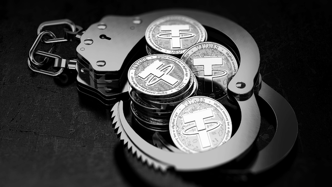 A black-and-white image shows silver Tether (USDT) coins stacked inside a pair of metal handcuffs, symbolizing the freezing or seizure of cryptocurrency funds. This visual directly relates to Tether's recent action of freezing approximately 39.27 million USDT across 10 wallets on the TRON network, with the coins depicted in restraints representing the immobilized assets linked to Xinbi Guarantee.