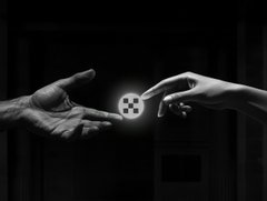 Two hands reach toward each other in a dark, monochromatic setting, one holding out a glowing token while the other extends to take it, symbolizing an exchange or transfer happening on the XRP Ledger (XRPL). The glowing token between them represents the seamless transactions and asset movement taking place "on the XRPL road."