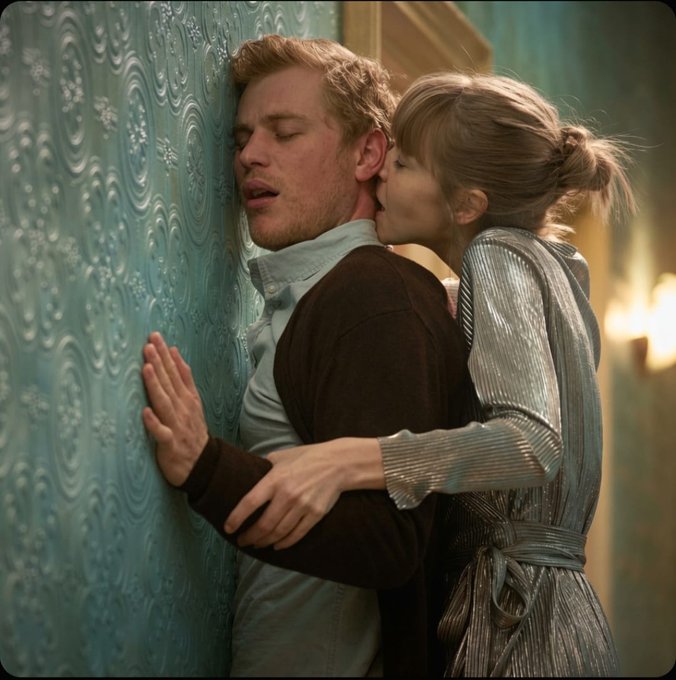 The image shows a man leaning against a wall with his arms wrapped around another person who has her head pressed up against him. They are both kissing, which suggests that they might be in a romantic or intimate moment. The scene takes place on a blue wall, and there is text above the couple's heads that reads "GN X Most people look at crypto and see tokens. I look at projects like @quipnetwork and see infrastructure. Because at the end of the day, AI models, scientific research, financial simulations, and future applications all need one thing: Compute". This implies a connection between their intimate moment and the broader context of technology and computing.