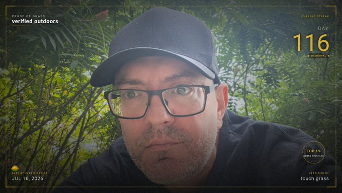 A close-up portrait of a man wearing a black cap and glasses, set against a lush green foliage backdrop. The image features overlay text including "PROOF OF GRASS," "verified outdoors," "CURRENT STREAK DAY 116," "IMDOPAL," "TOP 1% URBAN TROOPERS," and the date "JUL 16, 2026," tying directly into the post's celebration of Day 116 of the #ProofOfGrass challenge with the $TOUCHGRASS ticker.