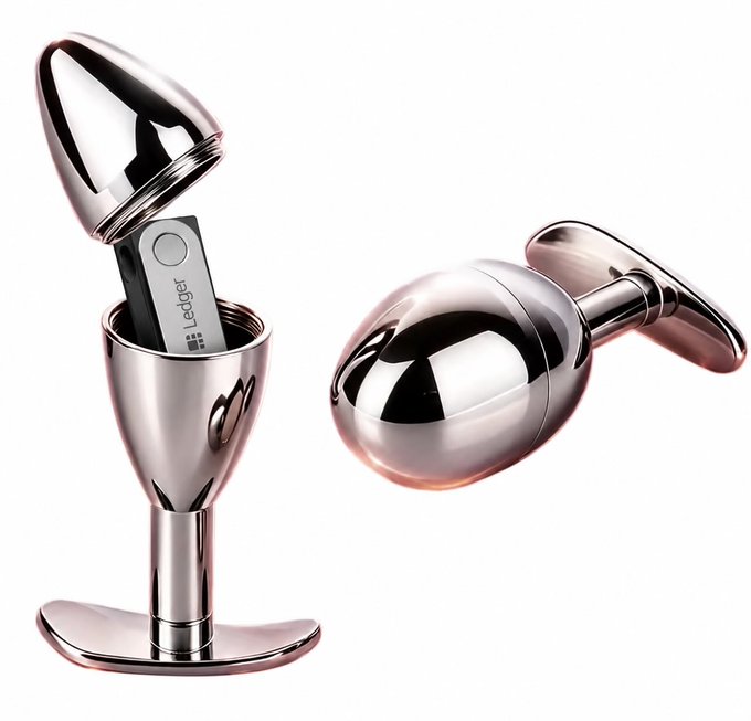 Two shiny chrome USB drives designed to resemble Ledger hardware wallets are shown, with one displaying the "Ledger" branding and logo on its screen. The image visually represents the post's message about securely storing cryptocurrency, using the recognizable egg-shaped form of Ledger devices to highlight safe storage amid rising crypto hacks.