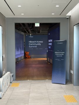 An entrance to the "Hibachi Korea Community Summit" event, marked by blue signage in what appears to be a conference center hallway.