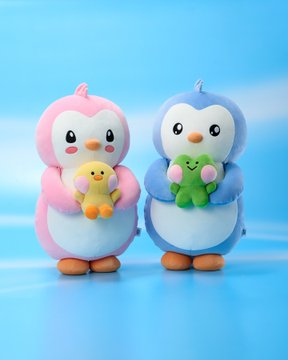 Two adorable plush penguins, one pink and one blue, each holding a tiny frog friend, stand together against a soft blue background—evoking a sweet, anticipatory feeling that pairs perfectly with the post's "tomorrow" message.